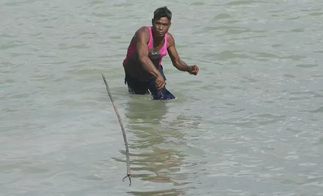 Tawan Klathale demonstrates to throw a spear to hunt fish for tourists in Moken village at Surin Islands in Phang Nga Province, Thailand, Wednesday, Dec. 11, 2024. (AP Photo/Sakchai Lalit)