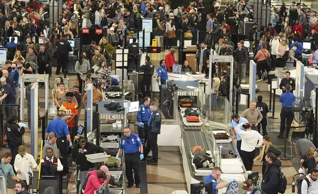 Travelers wade through the south security checkpoint in Denver International Airport Thursday, Dec. 19, 2024, in Denver. (AP Photo/David Zalubowski)