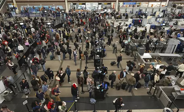 Travelers wade through the south security checkpoint in Denver International Airport Thursday, Dec. 19, 2024, in Denver. (AP Photo/David Zalubowski)