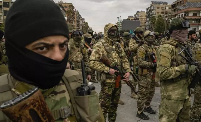 Members of the new armed forces, former rebels who overthrew Bashar Assad's government and now serve in the new Syrian government, stand in formation as they prepare for a military parade in downtown Damascus, Syria, Friday, Dec. 27, 2024. (AP Photo/Leo Correa)