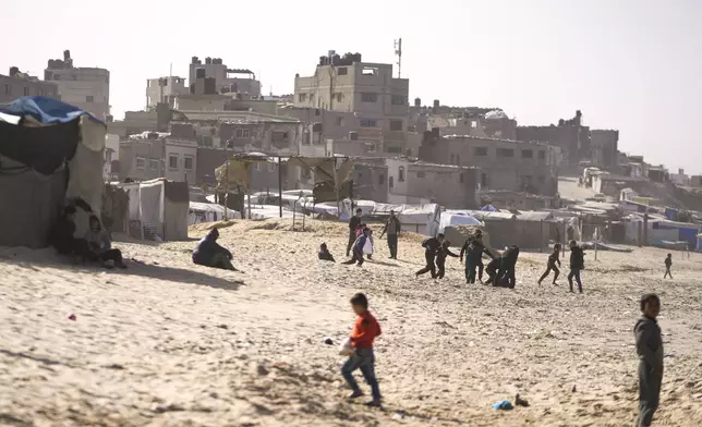 Children play on the sand in a camp for internally displaced Palestinians at the beachfront in Deir al-Balah, central Gaza Strip, Friday, Dec. 27, 2024. (AP Photo/Abdel Kareem Hana)
