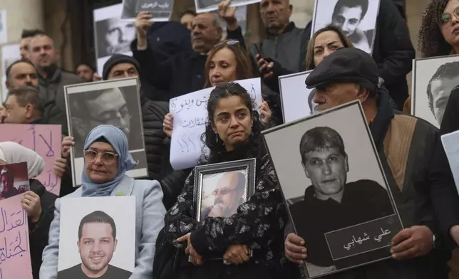 Wafaa Mustafa, center, holds a picture of her missing father during a demonstration in Damascus, Syria, Friday, Dec. 2024. The protesters demand accountability for members of Bashar Assad's government and military responsible for the detention, torture, or disappearance of their loved ones. (AP Photo/Ghaith Alsayed)