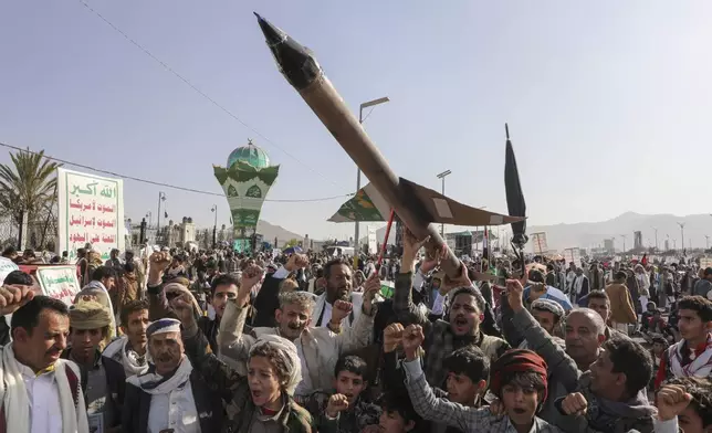 Houthi supporters carry a mock rocket and chant slogans during an anti-Israel rally in Sanaa, Yemen, Friday, Dec. 27, 2024. (AP Photo/Osamah Abdulrahman)