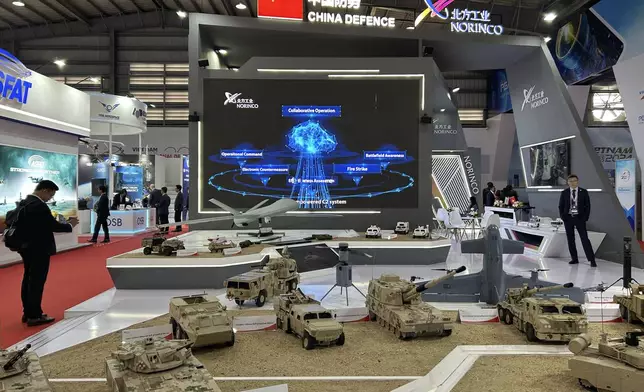 A man takes a photograph of China's NORINCO stall at the Vietnam International Defense Expo held in Hanoi, Vietnam, Thursday, Dec.19, 2024. (AP Photo/Aniruddha Ghosal)