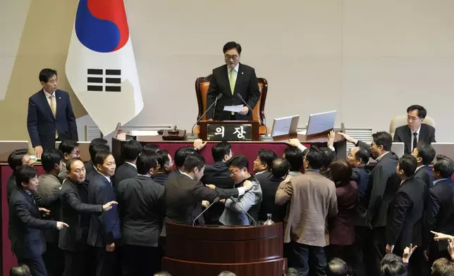 South Korea's National Assembly Speaker Woo Won Shik, top center, speaks as lawmakers of the ruling People Power Party protest during a plenary session for the impeachment motion against the country's acting President Han Duck-soo at the National Assembly in Seoul, South Korea, Friday, Dec. 27, 2024. (AP Photo/Ahn Young-joon)