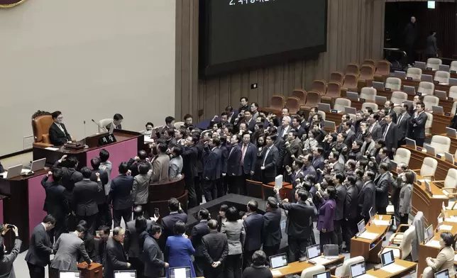 Lawmakers of the ruling People Power Party protest to South Korea's National Assembly Speaker Woo Won Shik, top left, during a plenary session for the impeachment motion against South Korean acting President Han Duck-soo at the National Assembly in Seoul, South Korea, Friday Dec. 27, 2024. (AP Photo/Ahn Young-joon)