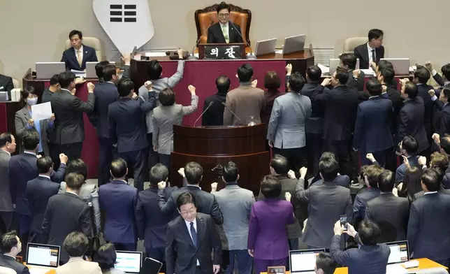 South Korea's opposition Democratic Party leader Lee Jae-myung, bottom center, walks past lawmakers of the ruling People Power Party protesting to South Korea's National Assembly Speaker Woo Won Shik, top center, during a plenary session for the impeachment motion against South Korean acting President Han Duck-soo at the National Assembly in Seoul, South Korea, Friday Dec. 27, 2024. (AP Photo/Ahn Young-joon)