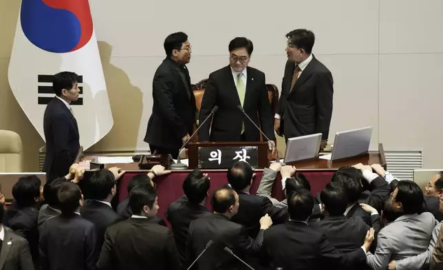 South Korea's ruling People Power Party floor leader Kweon Seong-dong, top right, argues with democratic Party floor leader Park Chan-dae, top left, as National Assembly Speaker Woo Won Shik stands between them during a plenary session for the impeachment motion against South Korean acting President Han Duck-soo at the National Assembly in Seoul, South Korea, Dec. 27, 2024. (AP Photo/Ahn Young-joon)