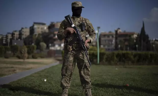 A member of the new armed forces, former rebel who took part in the overthrow of Bashar Assad's government and now serves in the new Syrian government, poses for a picture as he stands at a square before a military parade in Damascus, Syria, Friday, Dec. 27, 2024. (AP Photo/Leo Correa)