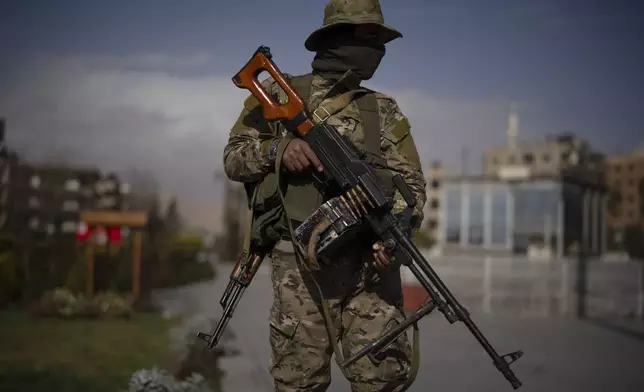 A member of the new armed forces, former rebel who took part in the overthrow of Bashar Assad's government and now serves in the new Syrian government, poses for a picture as he stands at a square before a military parade in Damascus, Syria, Friday, Dec. 27, 2024. (AP Photo/Leo Correa)