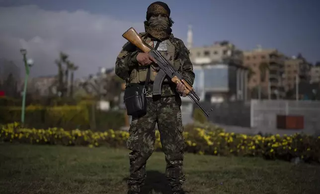 A member of the new armed forces, former rebel who took part in the overthrow of Bashar Assad's government and now serves in the new Syrian government, poses for a picture as he stands at a square before a military parade in Damascus, Syria, Friday, Dec. 27, 2024. (AP Photo/Leo Correa)