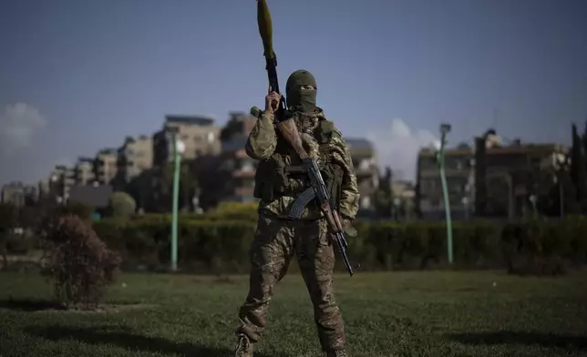 A member of the new armed forces, former rebel who took part in the overthrow of Bashar Assad's government and now serves in the new Syrian government, poses for a picture as he stands at a square before a military parade in Damascus, Syria, Friday, Dec. 27, 2024. (AP Photo/Leo Correa)