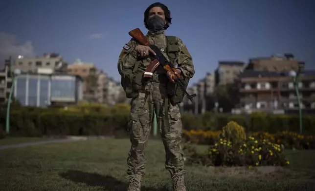 A member of the new armed forces, former rebel who took part in the overthrow of Bashar Assad's government and now serves in the new Syrian government, poses for a picture as he stands at a square before a military parade in Damascus, Syria, Friday, Dec. 27, 2024. (AP Photo/Leo Correa)