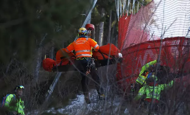 Medical staff are carrying France's Cyprien Sarrazin after crashing into protections net during an alpine ski, men's World Cup downhill training, in Bormio, Italy, Friday, Dec. 27, 2024. (AP Photo/Alessandro Trovati)