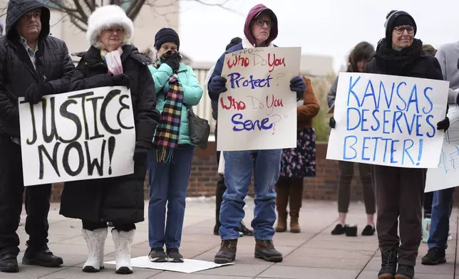 People listen to a speaker at a rally outside the federal courthouse on was was to be the opening day for a trial for former police detective Roger Golubski, Monday, Dec. 2, 2024, in Topeka, Kan. (AP Photo/Charlie Riedel)