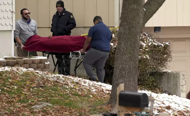 Workers carry a body from the home of former Kansas City, Kan. police detective Roger Golubski on Monday, Dec. 2, 2024, in Edwardsville, Kan. (AP Photo/Charlie Riedel)