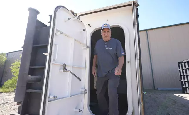 Ron Hubbard, owner of Atlas Survival Shelters, walks out the door of a bunker his company is building for a client during a tour of his operations in Sulphur Springs, Texas, on Aug. 27, 2024, (AP Photo/LM Otero)