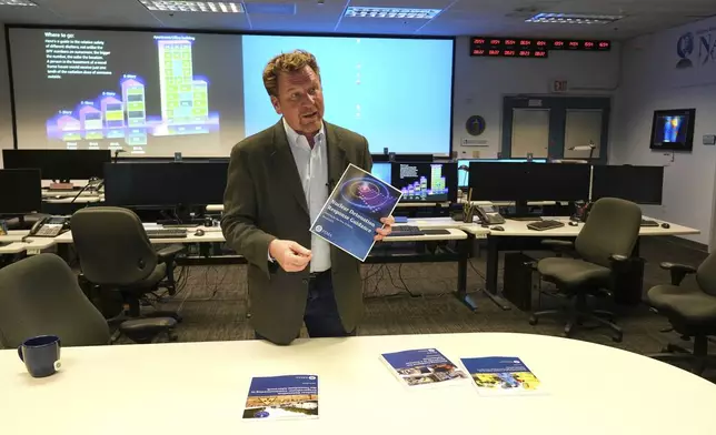 Brooke Buddemeier, a radiation safety specialist at Lawrence Livermore National Laboratory, holds a nuclear detonation response guide at the National Atmospheric Release Advisory Center in Livermore, Calif., Thursday, Aug. 22, 2024. (AP Photo/Terry Chea)