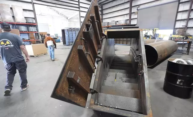 A bunker door and stairway sit ready for installation as Ron Hubbard, owner of Atlas Survival Shelters, gives a tour of his company's operations in Sulphur Springs, Texas, on Aug. 27, 2024, (AP Photo/LM Otero)