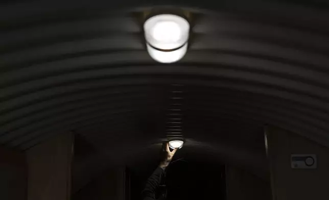 The owner, who asked not to be identified because of concerns about his privacy, turns off the lights in his underground shelter in an undisclosed Southern California city, on Dec. 16, 2024. (AP Photo/Jae C. Hong)