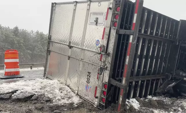 A tractor-trailer hauling a load of oranges sits on the side of the road after sliding off the Maine Turnpike early on Wednesday, Dec. 11, 2024, in New Gloucester, Maine. (AP Photo/David Sharp)