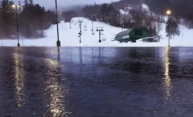 Rain water from a winter storm flows through the empty parking lot near the Panorama lift at the Gunstock Mountain Resort ski area , Wednesday, Dec. 11, 2024, in Gilford, N.H. (AP Photo/Charles Krupa)