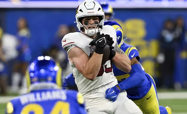 Arizona Cardinals tight end Trey McBride (85) makes a catch while Los Angeles Rams safety Quentin Lake tackles him during the first half of an NFL football game Saturday, Dec. 28, 2024, in Inglewood, Calif. (AP Photo/Alex Gallardo)