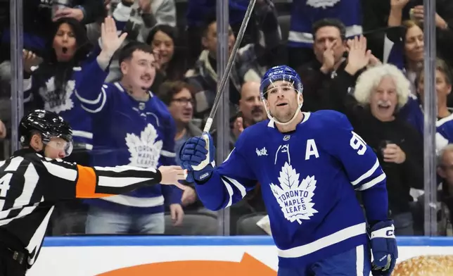 Toronto Maple Leafs' John Tavares (91) celebrates after his goal against the Washington Capitals during first-period NHL hockey game action in Toronto, Saturday, Dec. 28, 2024. (Frank Gunn/The Canadian Press via AP)