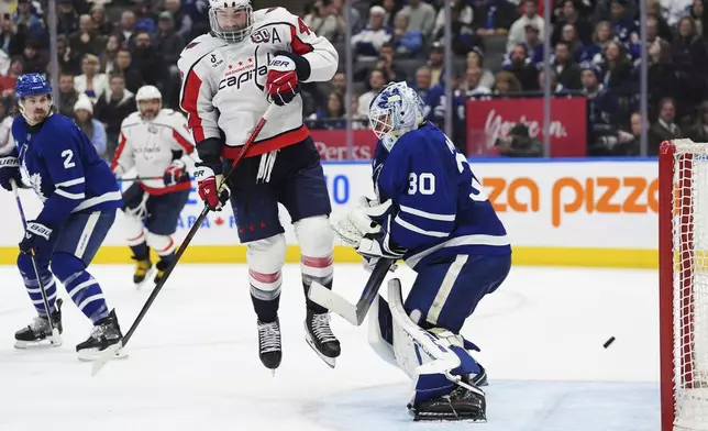 Washington Capitals' Tom Wilson (43) scores against Toronto Maple Leafs goaltender Matt Murray (30) during third-period NHL hockey game action in Toronto, Saturday, Dec. 28, 2024. (Frank Gunn/The Canadian Press via AP)