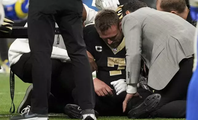 New Orleans Saints tight end Taysom Hill (7) goes down with an injury during the second half of an NFL football game against the Los Angeles Rams, Sunday, Dec. 1, 2024, in New Orleans. (AP Photo/Gerald Herbert)