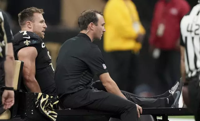 New Orleans Saints tight end Taysom Hill (7) is carted off the field during the second half of an NFL football game against the Los Angeles Rams, Sunday, Dec. 1, 2024, in New Orleans. (AP Photo/Gerald Herbert)