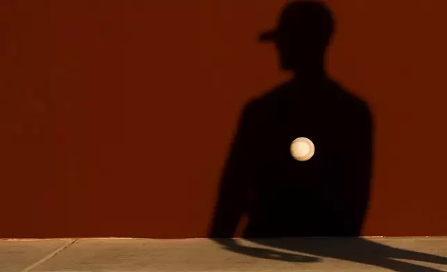 A member of the Seattle Mariners tosses a ball against a wall during drills at spring training baseball workouts, on Feb. 15, 2024, in Peoria, Ariz. (AP Photo/Lindsey Wasson)