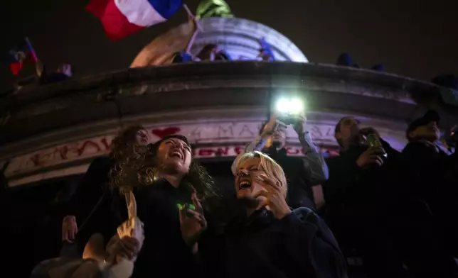 People gather at the Republique plaza in Paris after the second round of the legislative election, on July 7, 2024. (AP Photo/Louise Delmotte)