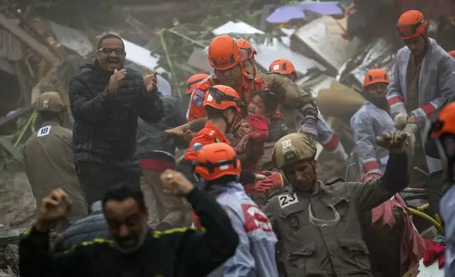 Emergency personnel carry a 4-year-old girl who was rescued from her collapsed house after heavy rains in Petropolis, Rio de Janeiro state, Brazil, on March 23, 2024. (AP Photo/Bruna Prado)