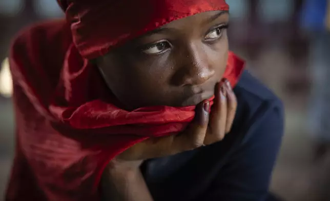 A girl waits in the family home of the late Ousmane Sylla, who died by suicide inside one of Italy's migrant detention centers, ahead of his body's arrival in Conakry, Guinea, on April 8, 2024. (AP Photo/Misper Apawu)