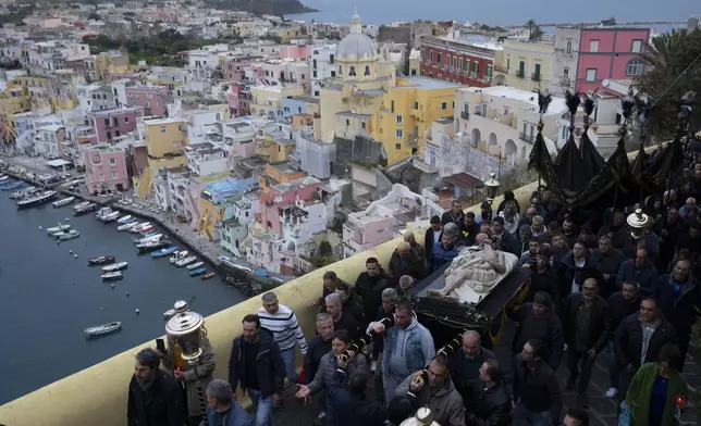 The faithful carry an 18th century wooden statue of Christ before the start of a procession the in Procida Island, Italy, on March 29, 2024. (AP Photo/Alessandra Tarantino)