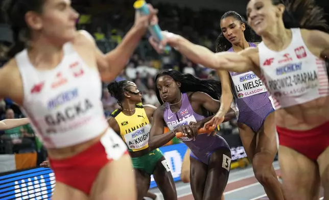 Ama Pipe, from Britain, center, receives the baton from teammate Lina Nielsen in a women's 4 X 400 meters relay heat during the World Athletics Indoor Championships at the Emirates Arena in Glasgow, Scotland, on March 3, 2024. (AP Photo/Bernat Armangue)