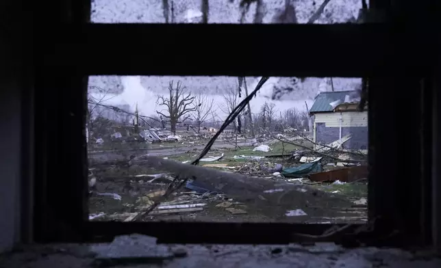 Debris is visible through the window of a damaged home following severe storms in Lakeview, Ohio, on March 15, 2024. (AP Photo/Joshua A. Bickel)