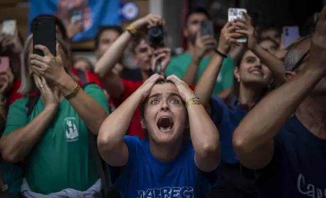 Assistants react as members of "Castellers de Vilafranca" try to form a "Castell" or human tower, during the 29th Human Tower Competition in Tarragona, Spain, on Oct. 6, 2024. (AP Photo/Emilio Morenatti)