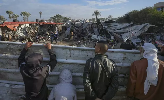 Palestinians survey the aftermath of an Israeli army airstrike on Wednesday at the Muwassi camp for displaced people near Khan Younis, in the southern Gaza Strip, on Thursday, Dec. 5, 2024. Palestinian health officials reported that at least 21 people were killed in the strike. (AP Photo/Abdel Kareem Hana)