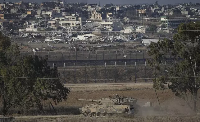 An Israeli armored vehicle transits around the Israel-Gaza border, as seen from southern Israel, Sunday Dec. 1, 2024. (AP Photo/Tsafrir Abayov)