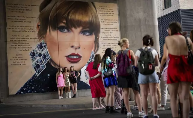 FILE - Taylor Swift fans pose in front of a mural before attending Swift's concert on June 21, 2024 in London. (Photo by Scott A Garfitt/Invision/AP, File)