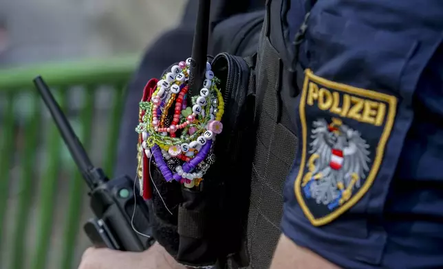 FILE - A police officer is decorated with Taylor Swift bracelets while guarding the city center in Vienna on Aug.8, 2024. (AP Photo/Heinz-Peter Bader, File)