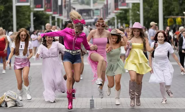 FILE - Fans of singer Taylor Swift arrive for her concert at Wembley Stadium in London on Aug. 15, 2024. (AP Photo/Alastair Grant, File)