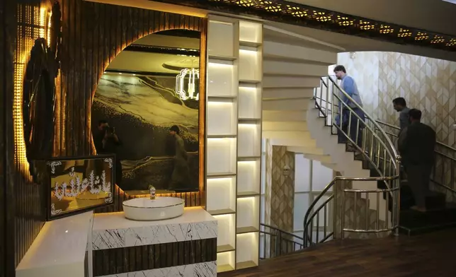 Men walk through a luxury house in the city of Kabul, Afghanistan, Sept. 23, 2024. (AP Photo/Siddiqullah Alizai)