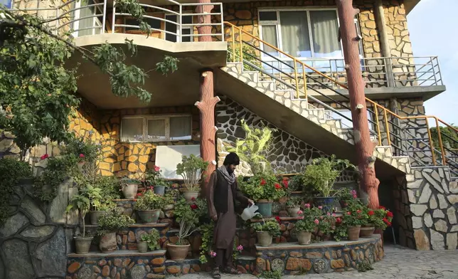 A man waters flowers outside a luxury house in the city of Kabul, Afghanistan, Sept. 29, 2024. (AP Photo/Siddiqullah Alizai)