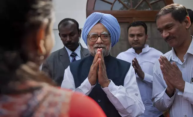 FILE - Former Indian prime minister Manmohan Singh, center, gestures after a short meeting with the newly elected office bearers of "National Students' Union Of India" (NSUI), who called on him at his residence in New Delhi, India, Tuesday, March 17, 2015. (AP Photo/Tsering Topgyal, File)