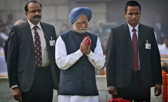 FILE - Indian Prime Minister Manmohan Singh, center, pays floral tributes at Rajghat, the memorial of Mahatma Gandhi, on his death anniversary in New Delhi, India, Monday, Jan. 30, 2014. (AP Photo/Manish Swarup, File)