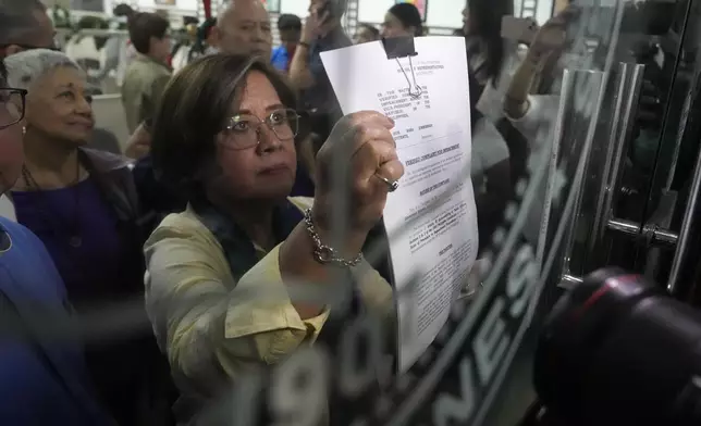 Former Senator Leila de Lima shows an impeachment complaint which they will file against Philippine Vice President Sara Duterte as they wait for the secretary general to receive it at the House of Representatives in Quezon City, Philippines on Monday, Dec. 2, 2024. (AP Photo/Aaron Favila)