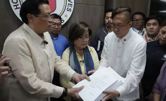 House Secretary General, Reginald Velasco, left, receives an impeachment complaint filed Monday, Dec. 2, 2024 against Philippine Vice President Sara Duterte by several prominent opponents and activists, including former Senator Leila de Lima, center, and Akbayan Partylist Representative Perci Cendana, right, at the House of Representatives in Quezon City, Philippines. (AP Photo/Aaron Favila)